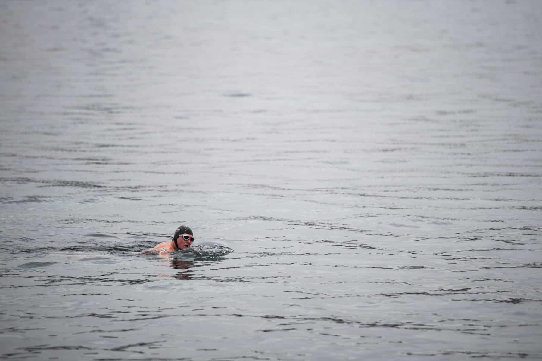 un baigneur dans le Léman juste avant la tombée de la nuit